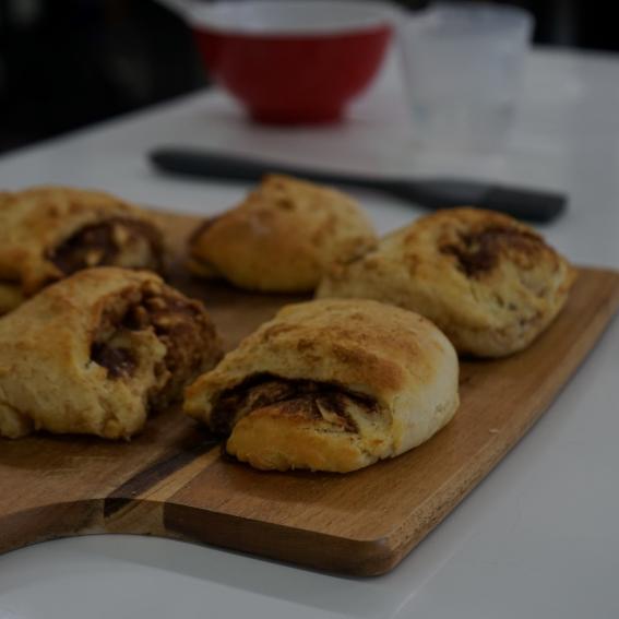 Backed cinnamon scrolls on a wooden chopping board