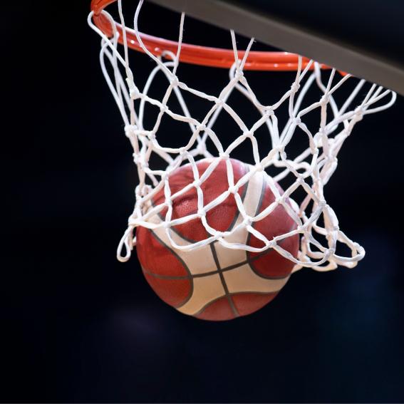 Basketball being shot through a basketball net.