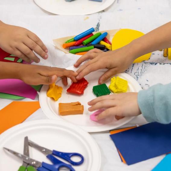 Childrens hands reaching into art supplies