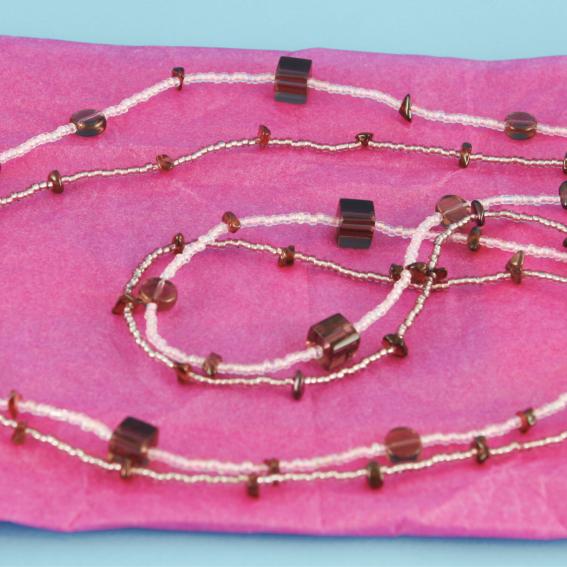 Beaded necklace on a pink background.
