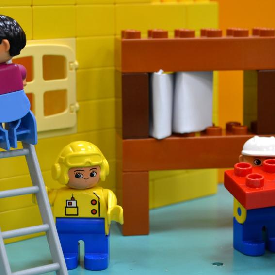 Lego characters building a house.