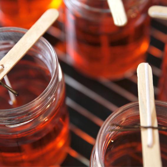 Red candles with popsicle sticks in the making.