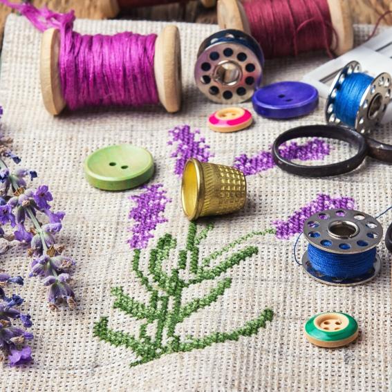 Colourful stiches on top of an embroidery mat.