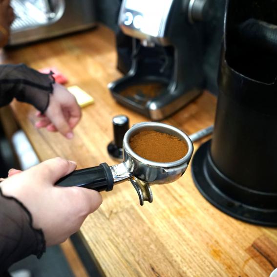 A young person holding a coffee grinder