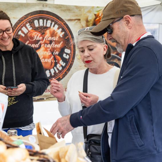Stallholder liaising with 2 customers about their spice products