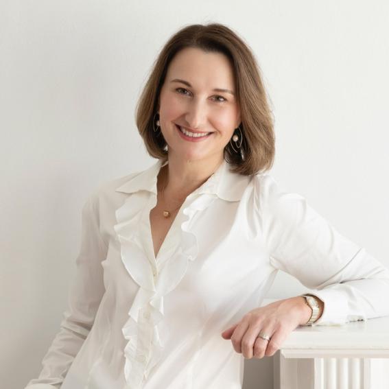 Headshot of Kyra Geddes in a white blouse.