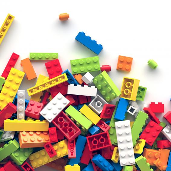 Colourful Lego laid out on a white background.