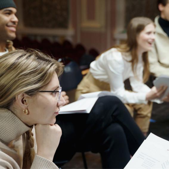 People sitting in a circle reciting poetry.