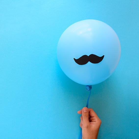 Generic image of a hand holding a balloon with moustache icon in front of a blue background