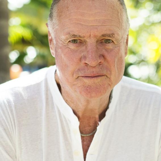 Mike Carlton in white shirt with green trees background
