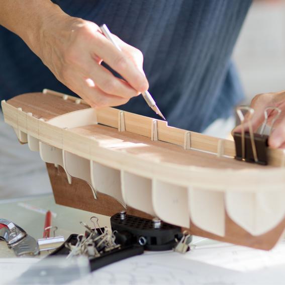 A person working on a model ship build.