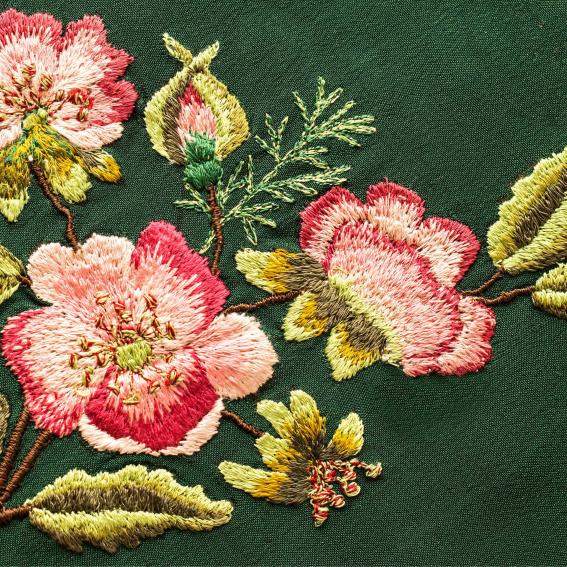 Embroidered red and yellow flowers on a green fabric