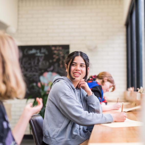 Image of a young person doing homework and listening to a tutor