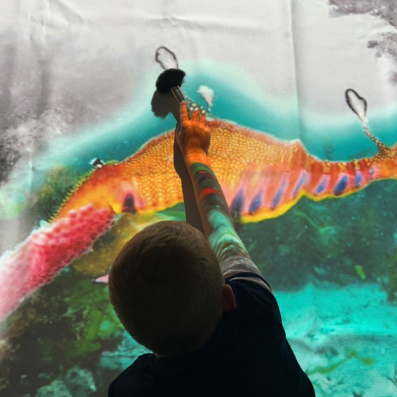 Child playing with interactive digital floor projection
