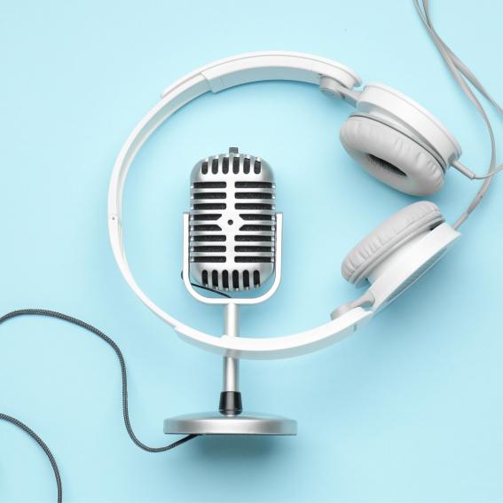 Headphones, a microphone and a cord laying down on a blue background.