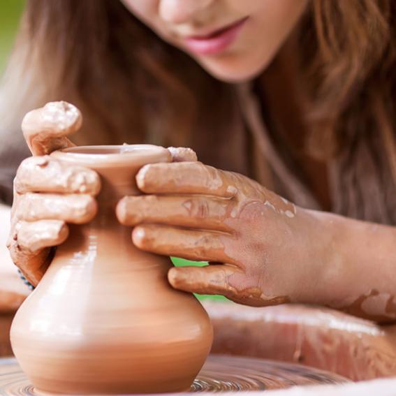 Person creating pottery on wheel