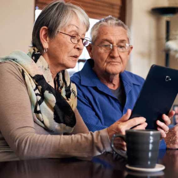 Two seniors looking over their e-tablet