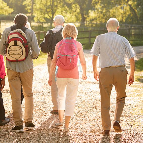 Seniors on a walk with backpacks