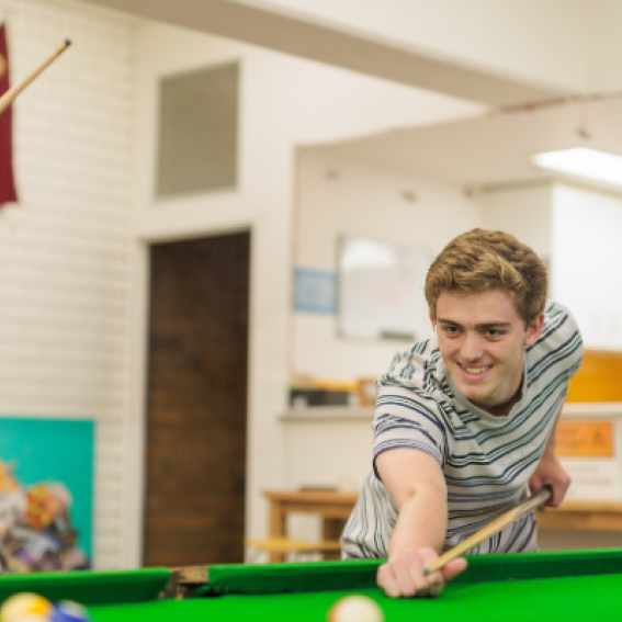 Young person playing pool at youth centre