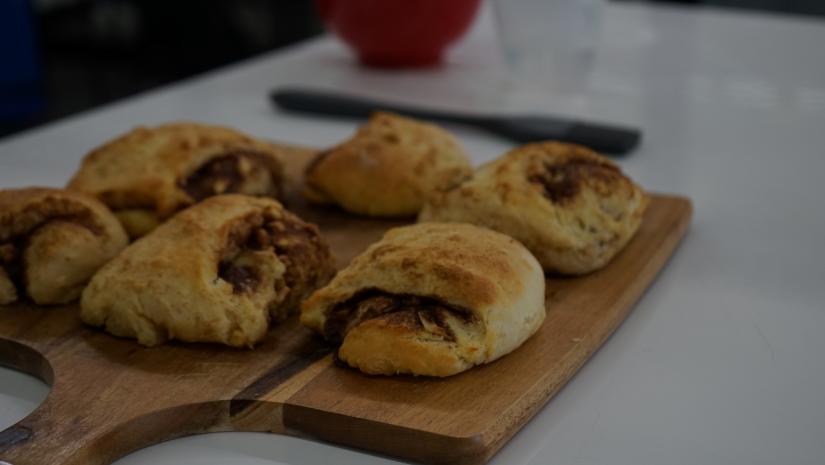 Backed cinnamon scrolls on a wooden chopping board