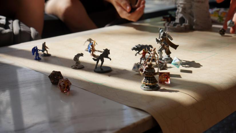 Miniatures on a square map with Dungeons and Dragons dice.