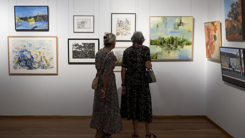 Two women looking at artwork on a wall