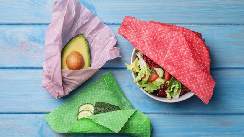 Colourful beeswax wraps covering fresh food items.