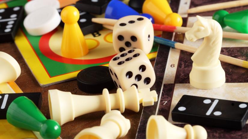 Colourful board game pieces and dice on a table.