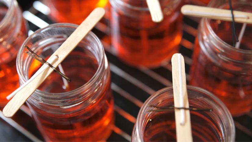 Red candles with popsicle sticks in the making.