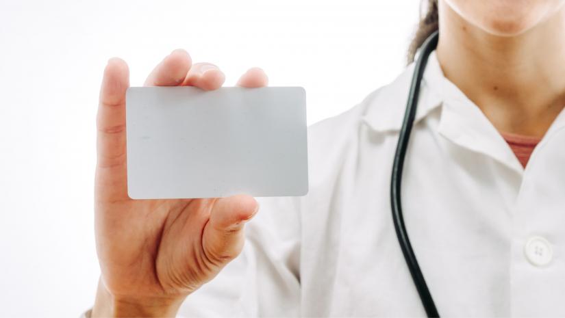 Doctor holding up a blank card.