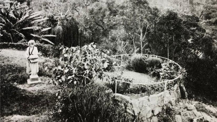 Old black and white photo of Ethel Turner standing in her garden.