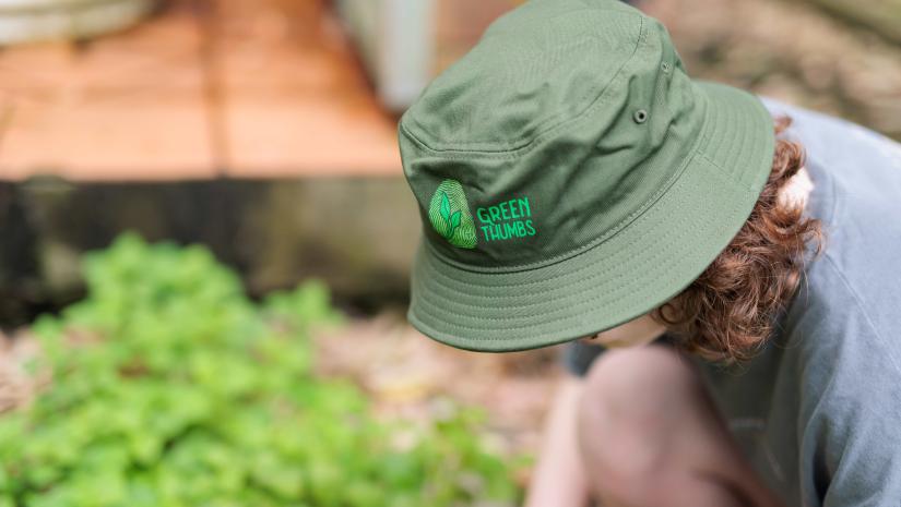 Green Thumbs A Green Thumbs volunteers wearing a Green Thumbs hat gardening at the Centre