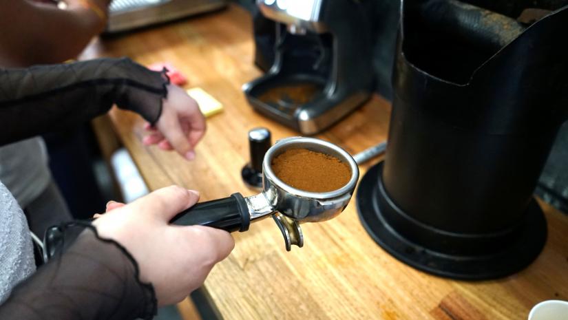 A young person holding a coffee grinder