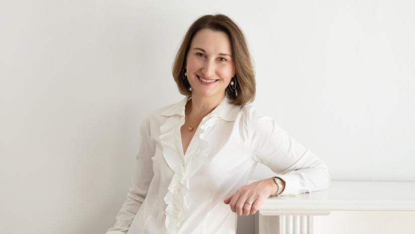 Headshot of Kyra Geddes in a white blouse.