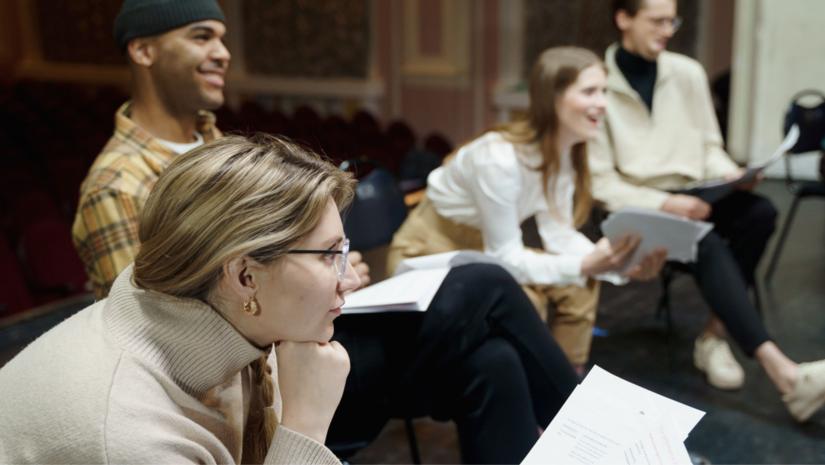 People sitting in a circle reciting poetry.