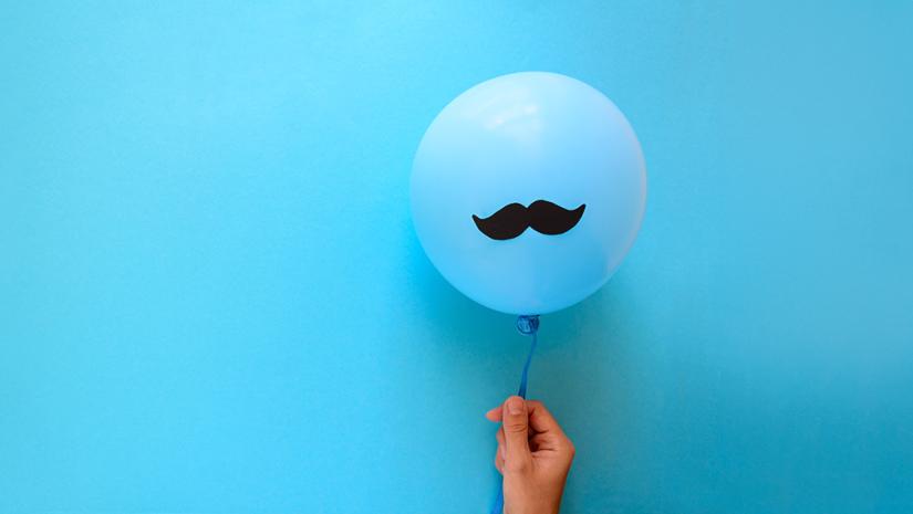 Generic image of a hand holding a balloon with moustache icon in front of a blue background