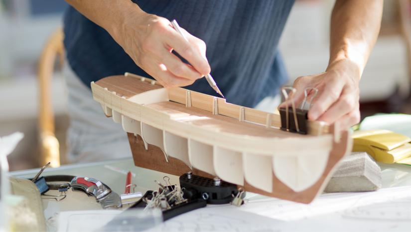 A person working on a model ship build.