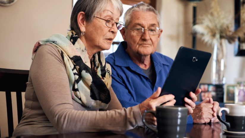 Two seniors looking over their e-tablet