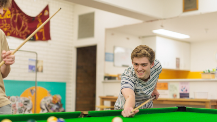 Young person playing pool at youth centre